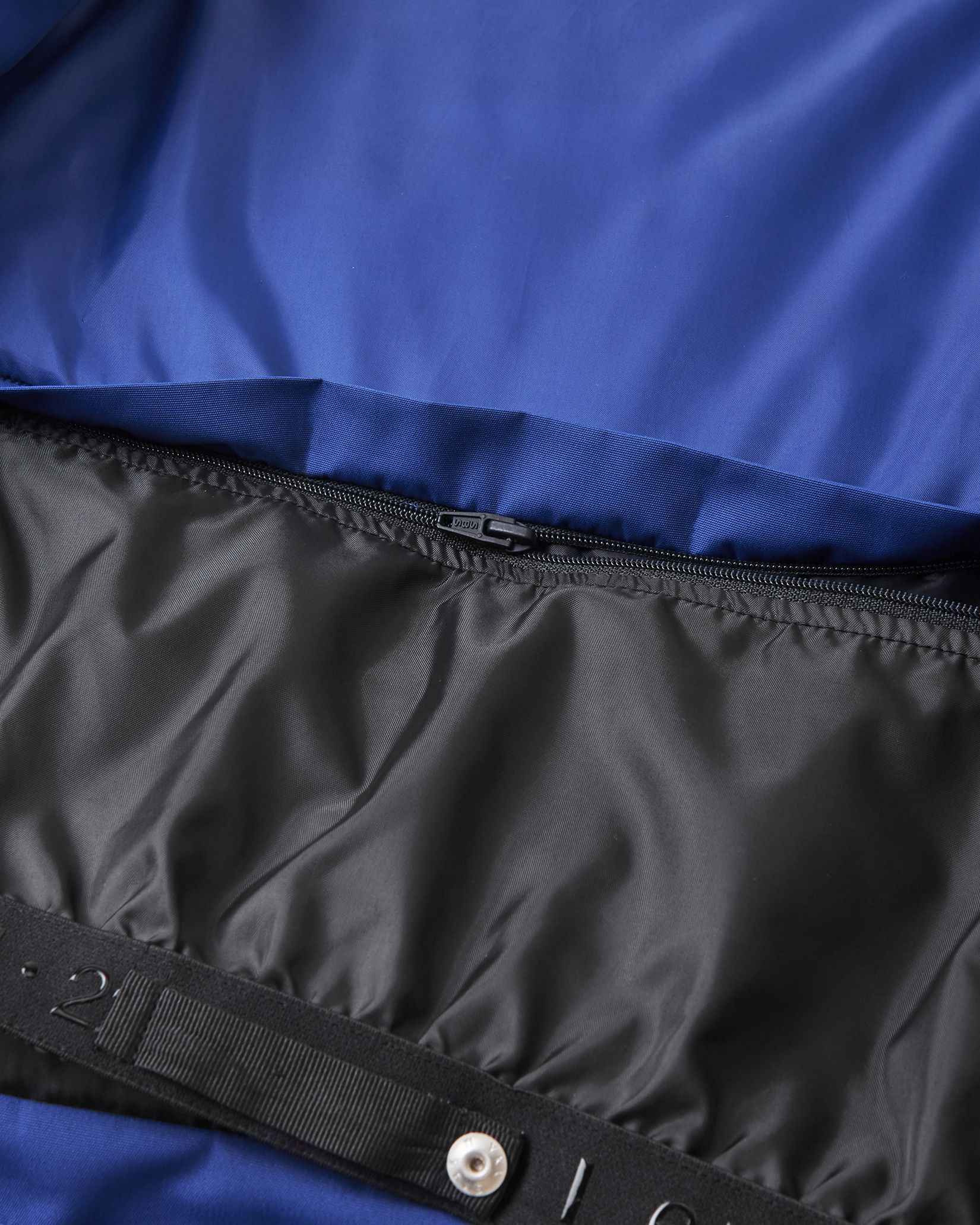Metal snap buttons secure the black inner lining inside the blue Reima ski jacket.