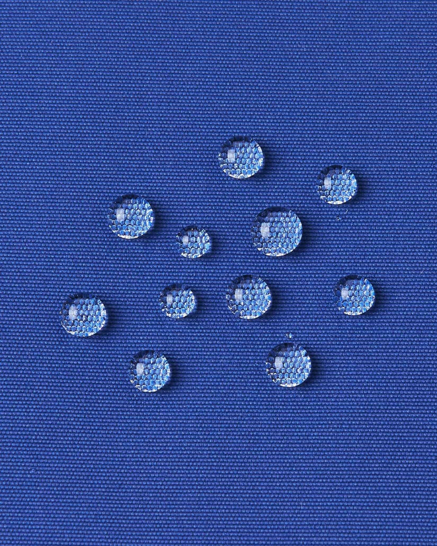 Water beads up on the twilight blue fabric of the Reima ski jacket to demonstrate its water resistance.