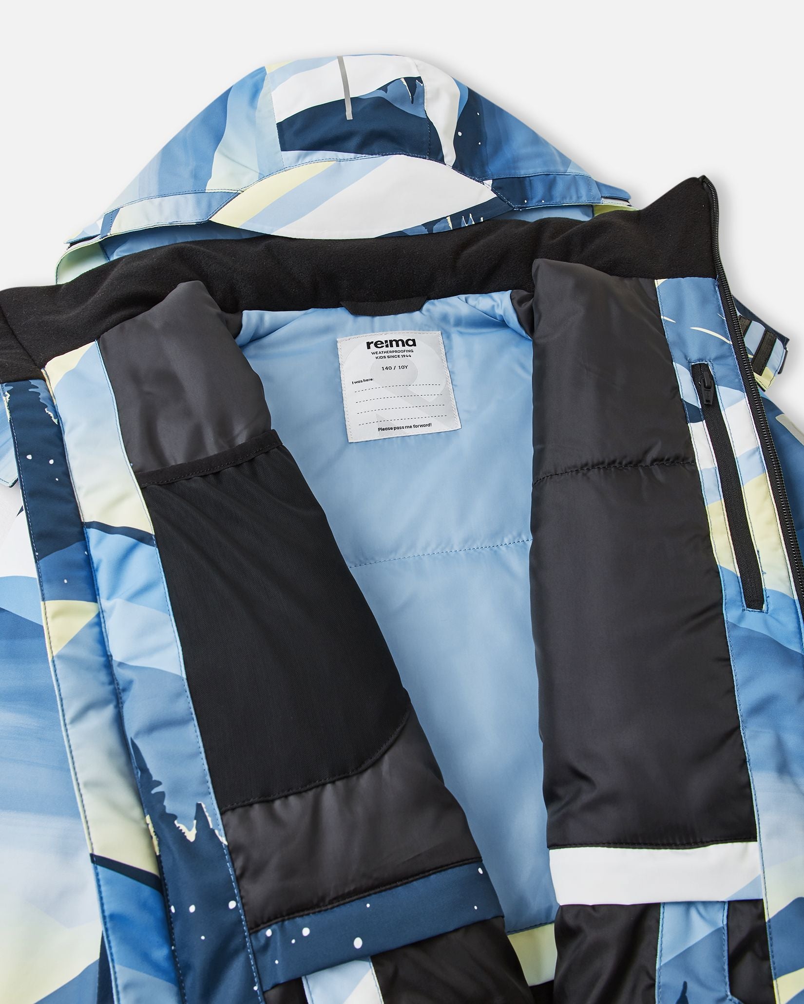 Inside view of the ocean blue Reima Tirro kids' waterproof ski jacket, showing the smooth winter lining, internal mesh goggle pocket, zippered chest pocket, and Reima name tag.