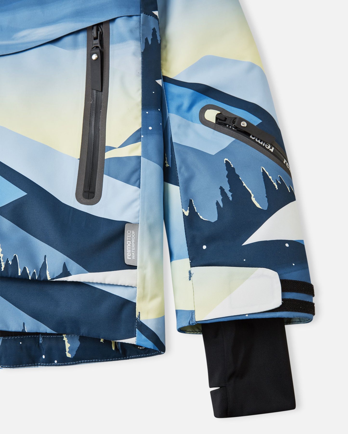 Detail view of the waterproof zippered sleeve ski pass pocket and the inner lycra cuff with thumbhole on the ocean blue Reima Tirro kids' ski jacket.