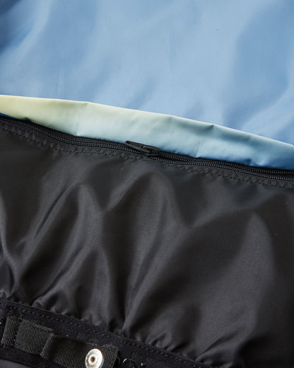 Close-up detail of the internal snap-button powder skirt on the ocean blue Reima Tirro kids' ski jacket, designed to block snow and cold air during skiing and snowboarding.