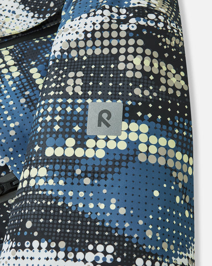 Close-up of the safety-enhancing reflective Reima logo patch on the sleeve of the soft black Tirro kids' waterproof ski jacket, providing visibility in low-light winter conditions.