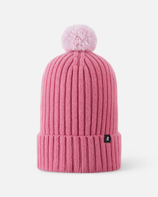 Front flat lay view of the soft coral pink Reima Topsu kids' winter beanie. The image highlights the warm ribbed knit texture, a wide folded brim for extra ear protection, and a matching playful yarn pom-pom on top.
