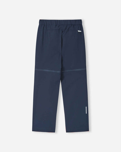 Back view of the navy blue Reima Tuplat kids' convertible hiking pants, displaying the smooth, durable outdoor construction, clean seat design, and a highly visible reflective safety strip on the lower calf.
