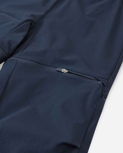 Macro close-up of the hidden zipper detail on the Reima Tuplat kids' navy blue convertible hiking pants, showcasing the smooth, high-quality zipper hardware used to detach the lower pant legs and easily convert them into shorts.