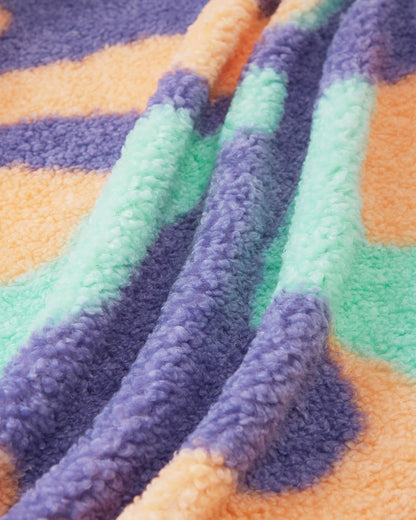 Macro close-up of the ultra-soft, thick teddy fur fleece used on the apricot Reima Tupsis kids' jacket, highlighting the plush texture and the bright orange, purple, and mint green camo pattern designed for cozy winter layering.