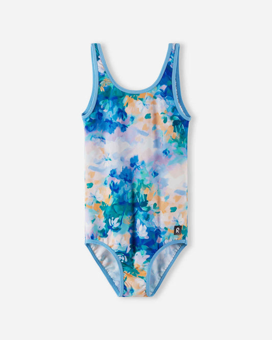 Front view of the Reima Uimaan girls' one-piece swimsuit in a cool blue and peach abstract watercolor print, featuring a secure fit, UPF sun protection, and a classic summer silhouette.