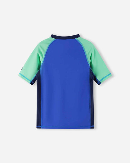 Back view of the sparkly blue Reima Uiva kids' short sleeve swim shirt, showing the comfortable athletic fit, raglan sleeves, and quick-drying UPF 50+ fabric ideal for active beach days.