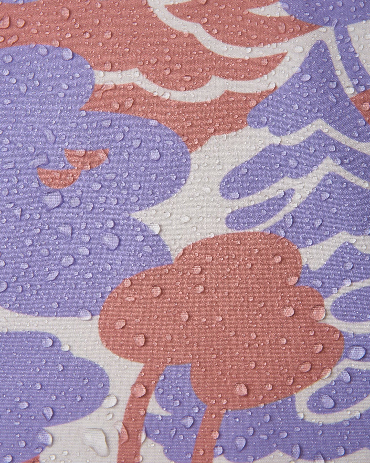 Macro close-up of water droplets beading and rolling off the surface of the Reima Vantti kids' blooming lilac softshell jacket, demonstrating the highly waterproof and dirt-repellent material.