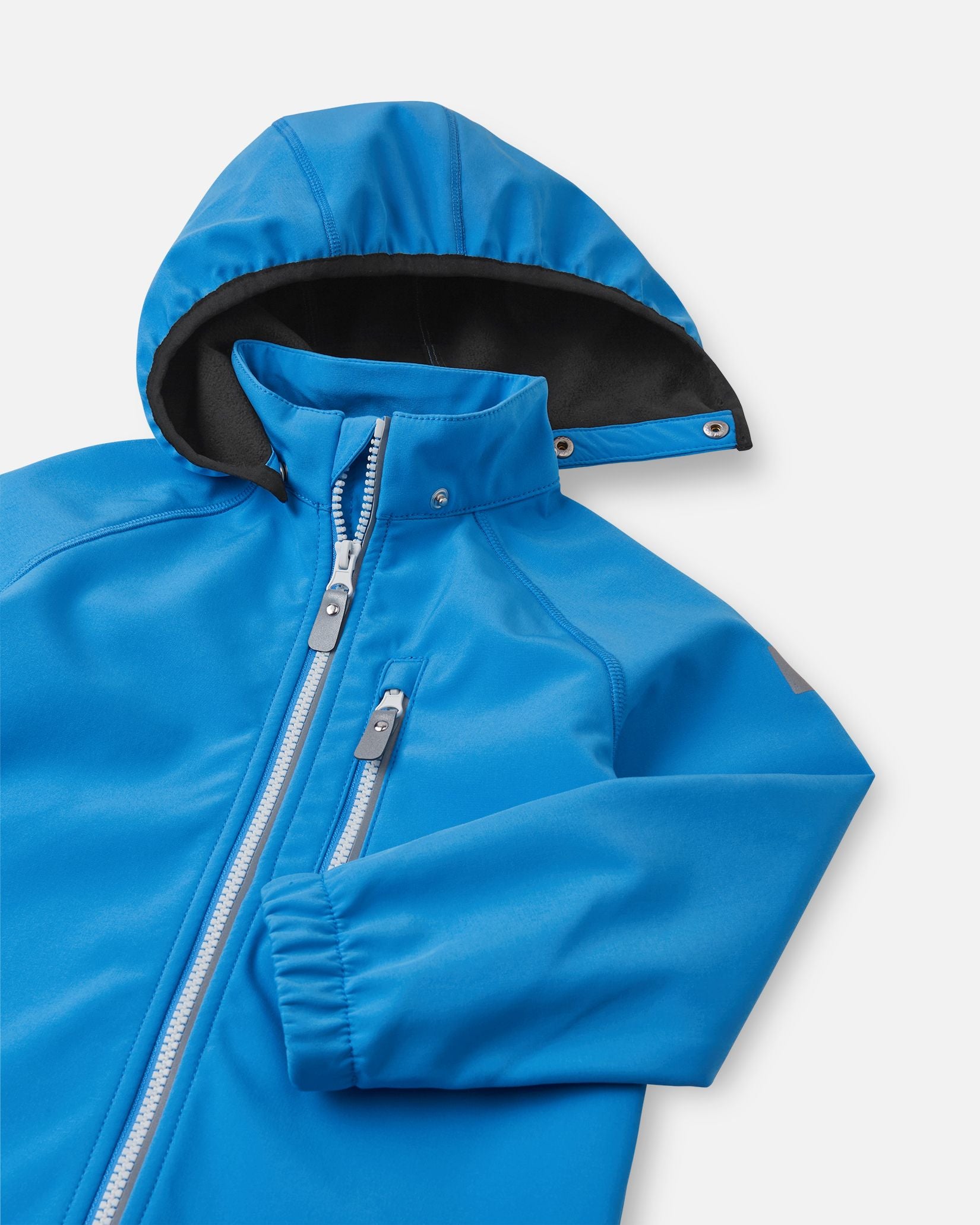 Close-up of the hood and high collar on the cool blue Reima Vantti kids' softshell jacket, showing the cozy, insulating black fleece lining designed to provide extra warmth without bulk.
