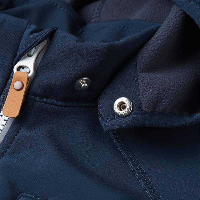 Close-up of the secure snap buttons on the collar of the Reima Vantti kids' softshell jacket, illustrating the child-safe detachable hood mechanism designed to easily pop off if caught.