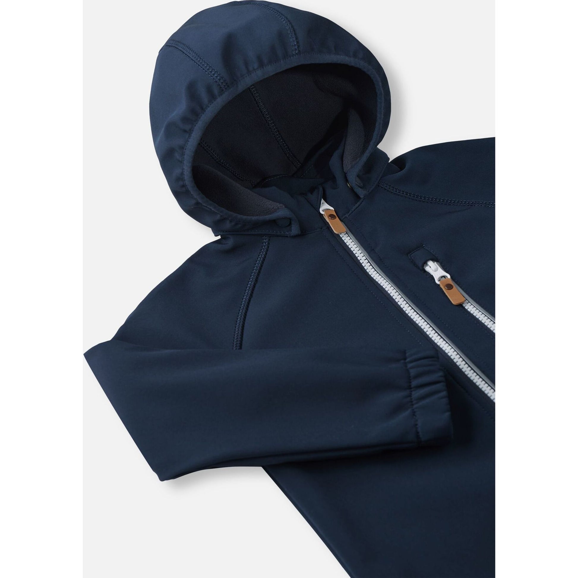 Close-up of the hood and high collar on the navy Reima Vantti kids' softshell jacket, showing the cozy, insulating fleece lining that provides extra warmth without bulk.