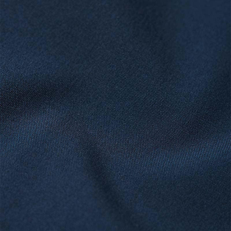 Macro texture detail of the navy blue Reima Vantti kids' softshell jacket, showing the tightly woven, dirt-repellent, and windproof outer shell material.