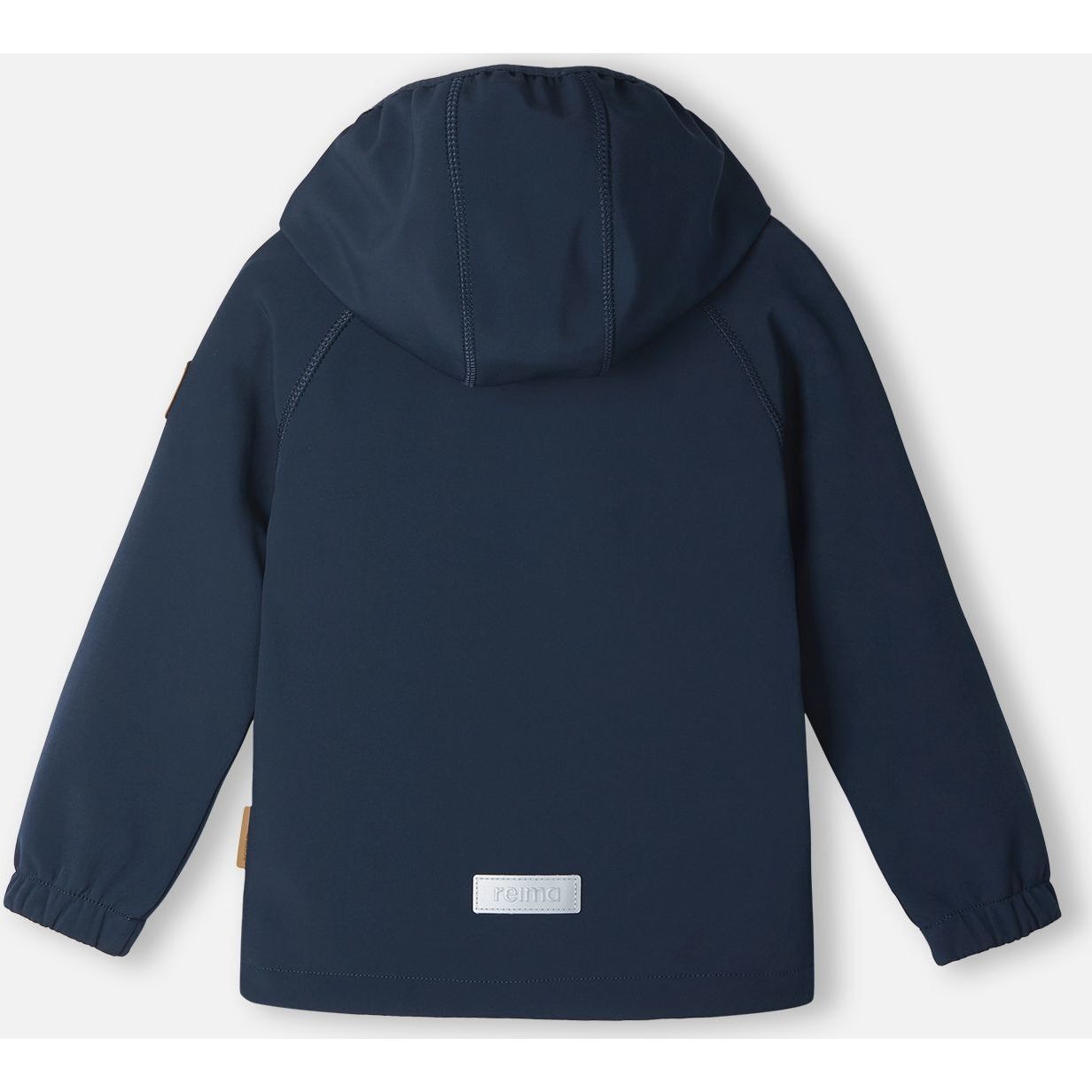 Back view of the navy blue Reima Vantti kids' softshell jacket, showcasing a comfortable active fit, raglan sleeves for mobility, and a highly visible reflective safety patch at the lower hem.