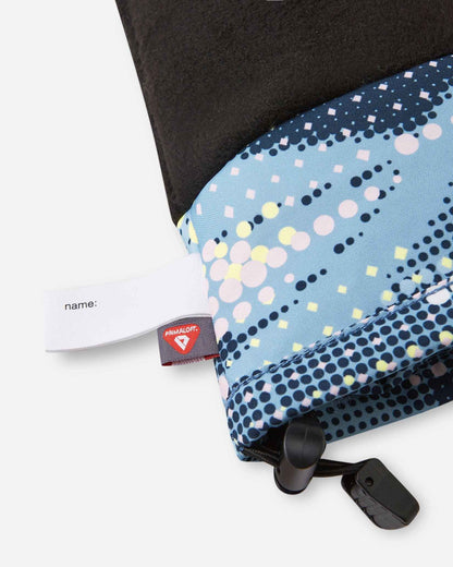 Detail of the inner cuff of the frozen blue Reima Vanukko kids' ski mittens, showing the soft black thermal fleece lining, a customizable blank name tag, and the premium PrimaLoft insulation label indicating high-performance winter warmth.