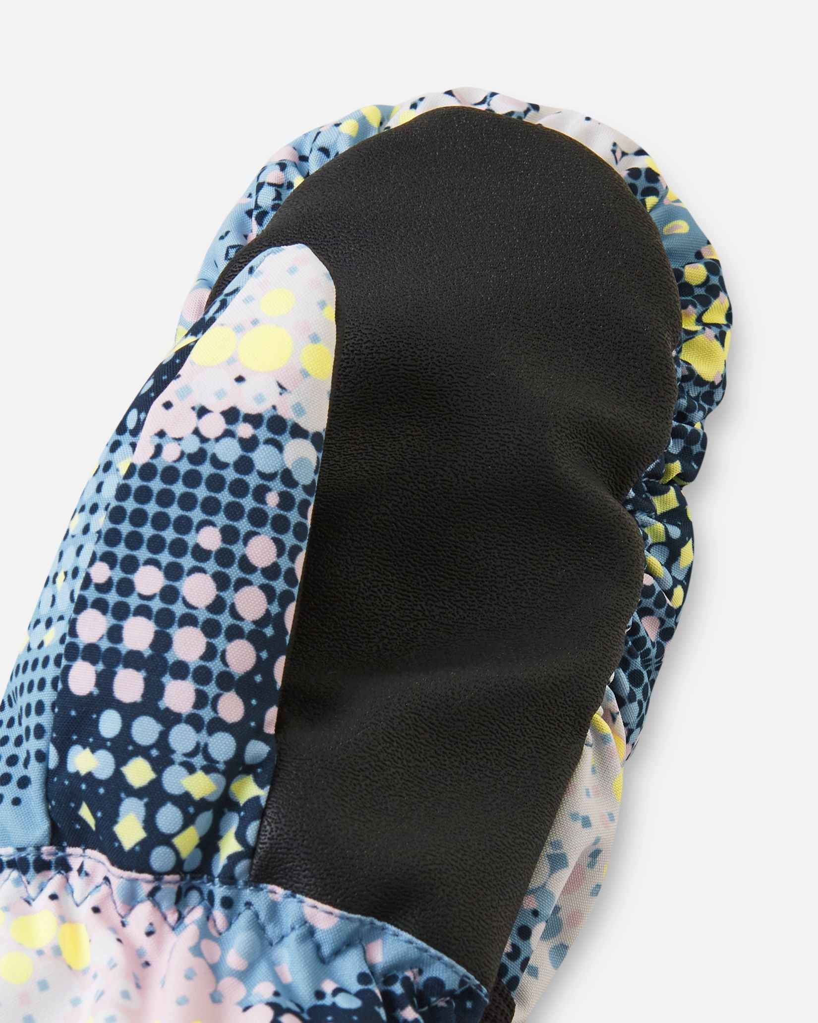 Close-up detail of the black reinforced palm and thumb material on the frozen blue Reima Vanukko kids' ski mittens, engineered for maximum durability and physical dexterity in the snow.