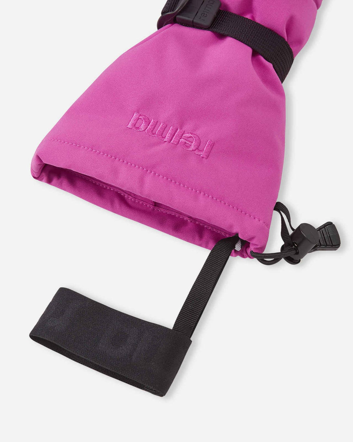 Close-up detail of the Reima Vanukko kids' winter mittens in fuchsia, highlighting the adjustable black wrist strap, secure buckle, and the embossed Reima brand logo.