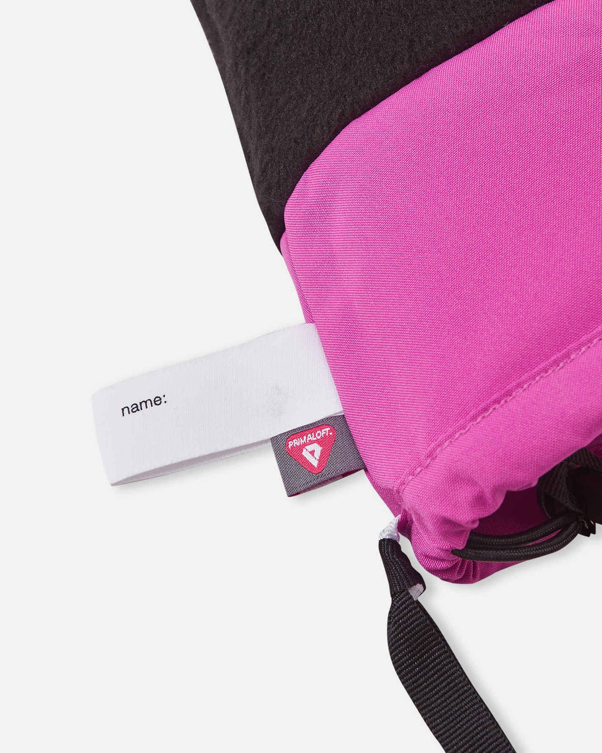 Detail shot of the inner cuff on the Reima Vanukko kids' ski mittens, displaying a blank sewn-in name tag and a PrimaLoft insulation label indicating premium winter warmth.