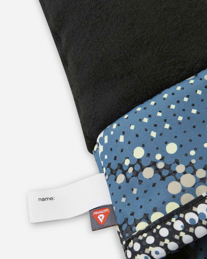 Close-up interior view of the soft black Reima Vanukko kids' ski mittens, showing the cozy thermal fleece lining, a customizable name tag, and a premium PrimaLoft insulation label indicating high-performance winter warmth.