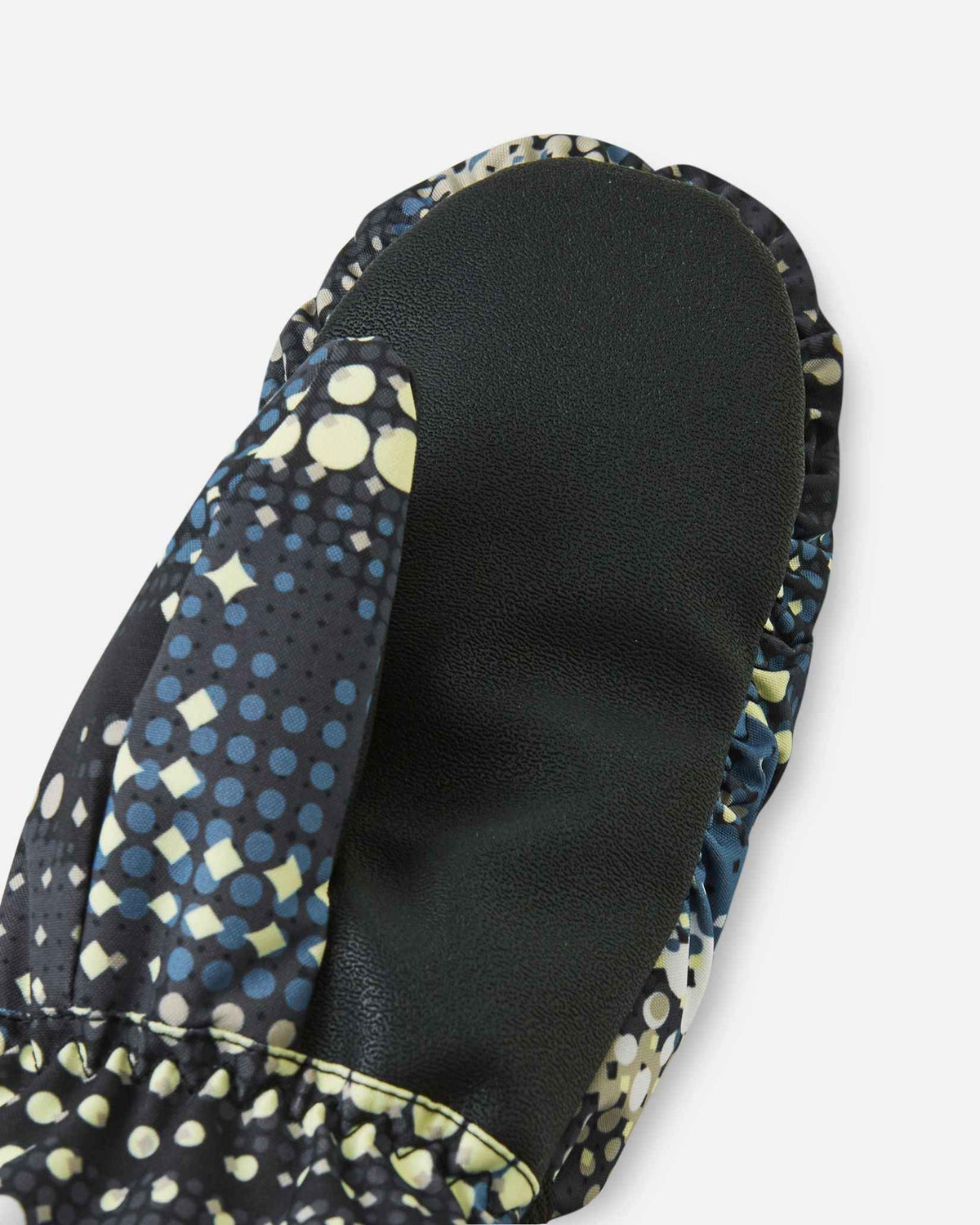 Close-up detail of the black reinforced palm and thumb material on the soft black Reima Vanukko kids' ski mittens, specifically engineered for tear resistance and a secure, non-slip grip on ski poles.