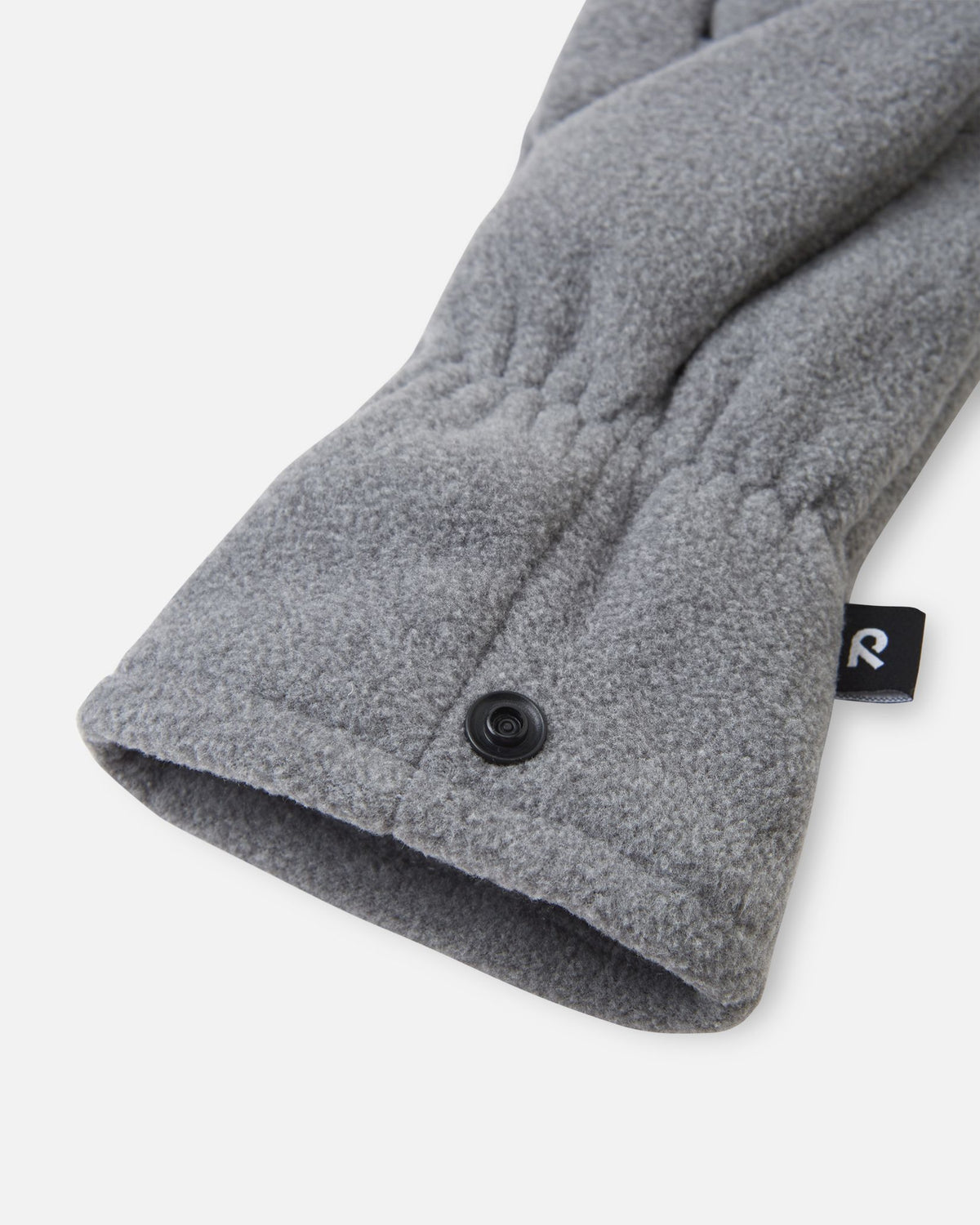 Close-up detail shot of the Reima Varmin kids' fleece gloves in melange grey, highlighting the warm fleece fabric, the gathered elastic wristband, and the practical black snap button fastener used to clip the pair together so they don't get separated.