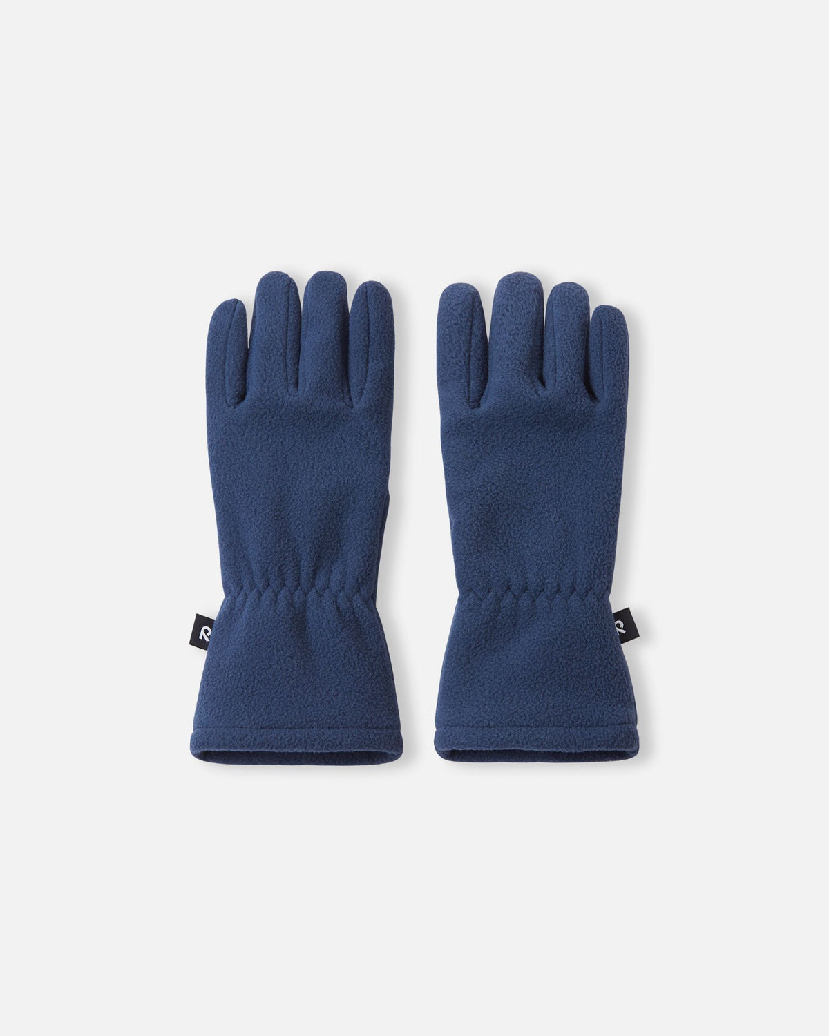 Top view of a pair of navy blue Reima Varmin kids' fleece gloves, featuring soft, warm fabric, a black Reima logo tag on the side, and elasticated wrists for a snug winter fit.