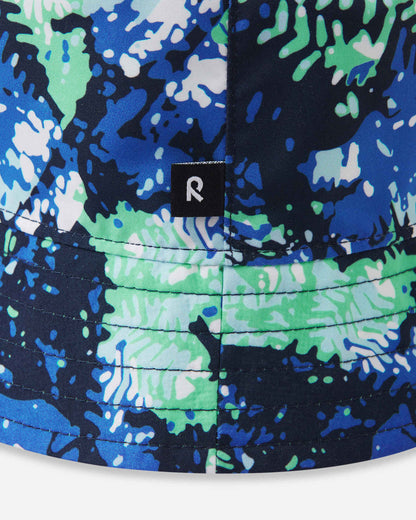 Close-up detail of the Reima Viehe kids' UPF 50+ reversible sun hat in fresh mint, highlighting the vibrant abstract pattern, neat brim stitching, and the signature black Reima logo tag.