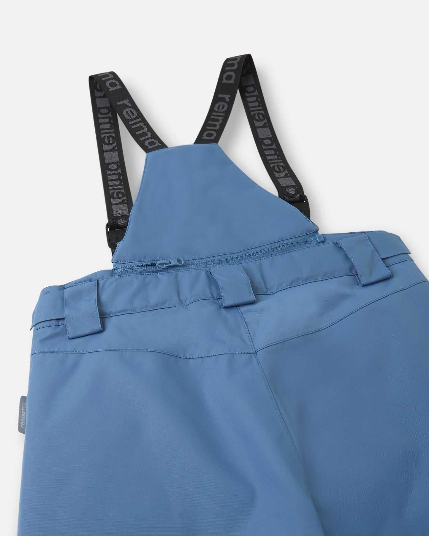 Detail view of the upper back on the blue ocean Reima Wingon kids' snow pants, featuring the stretchy high-back panel for extra core warmth, belt loops, and sturdy Reima-branded elastic suspenders.