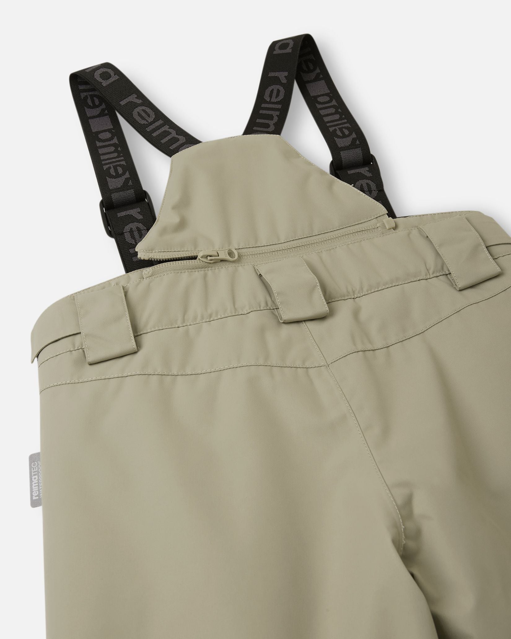 Detail view of the upper back on the earthy beige Reima Wingon kids' snow pants, featuring the stretchy high-back panel for extra core warmth, belt loops, and sturdy Reima-branded elastic suspenders.
