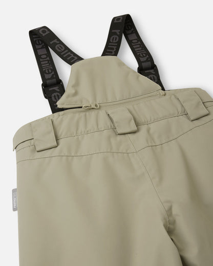 Detail view of the upper back on the earthy beige Reima Wingon kids' snow pants, featuring the stretchy high-back panel for extra core warmth, belt loops, and sturdy Reima-branded elastic suspenders.
